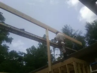Carpenter setting a ridge beam over a new addition frame — Ice Dam Removal by Roofing Brothers in Betterton