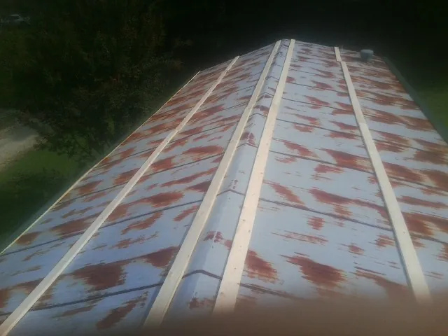Rusted metal roof panels with new wood purlins before replacement — Storm Damage Roof Repair in Betterton by Roofing Brothers
