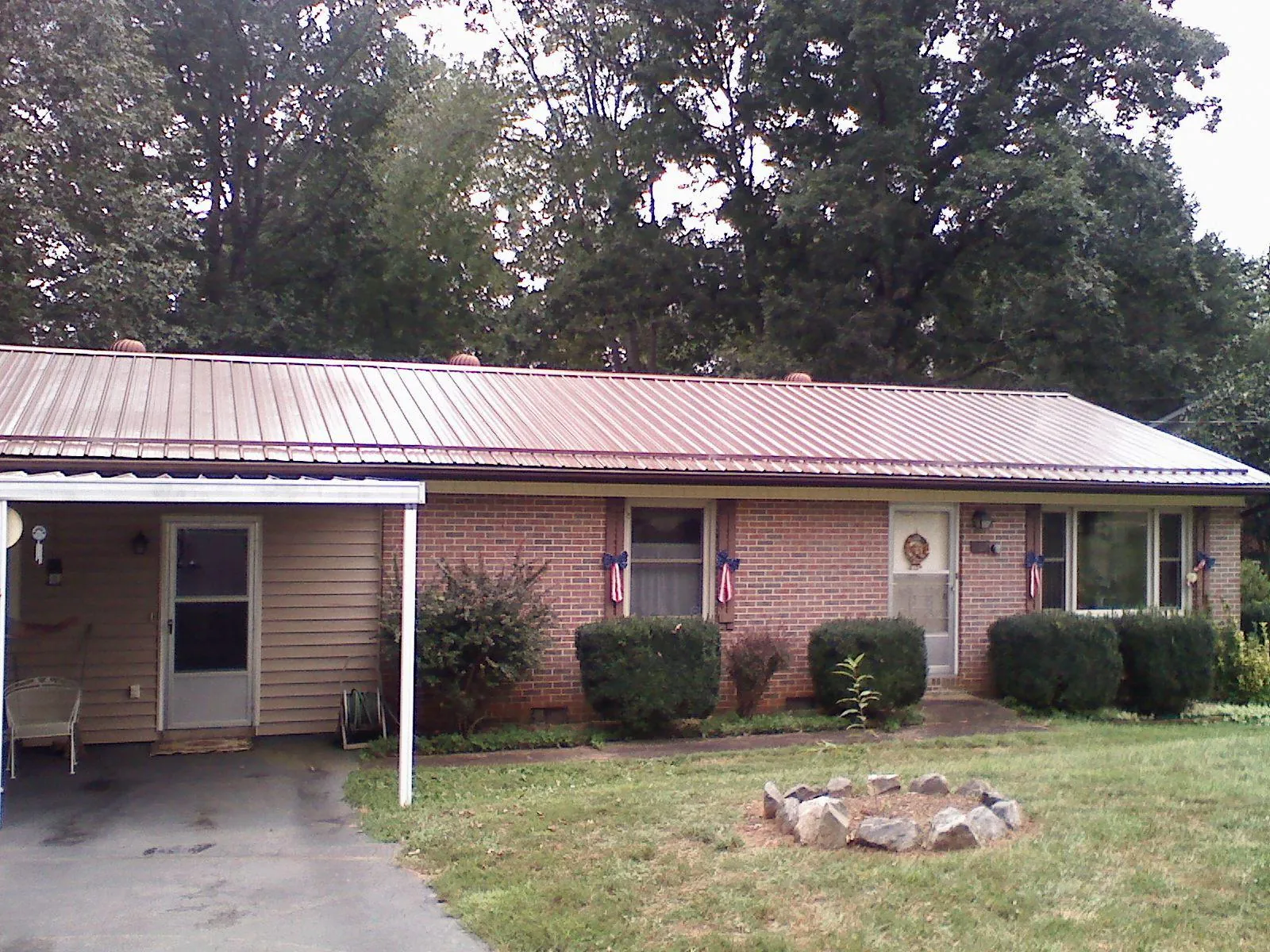 Bronze metal roof and carport on a brick ranch home — Roof Repair work by our crew in Betterton